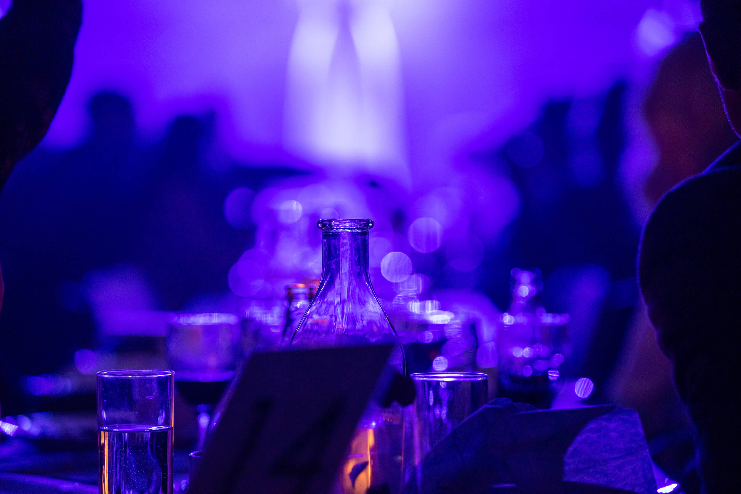 En närbild på dukning av långbord där ljuset är lila i bilden