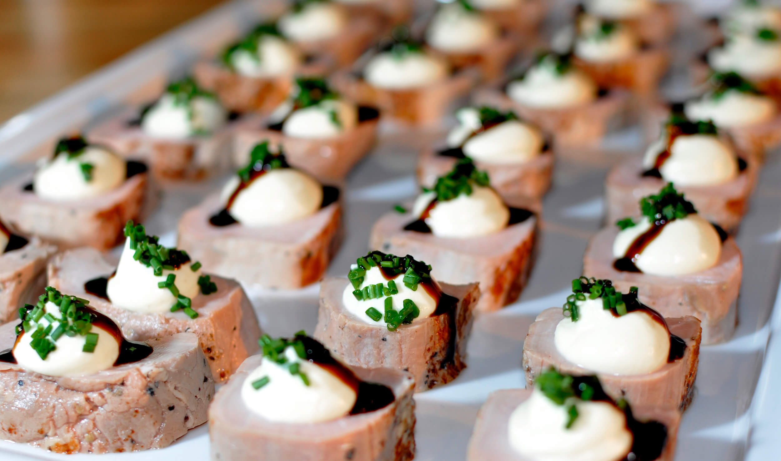 Köttbitar med en klick dressing, gräslök och balsamico på rad