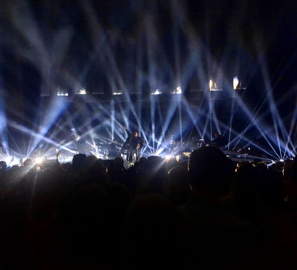 Person på scen framför publik samt strålkastare