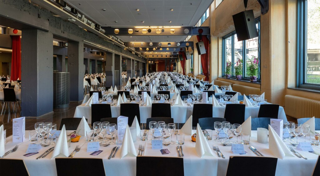 Ett långt rum med långbord uppdukade